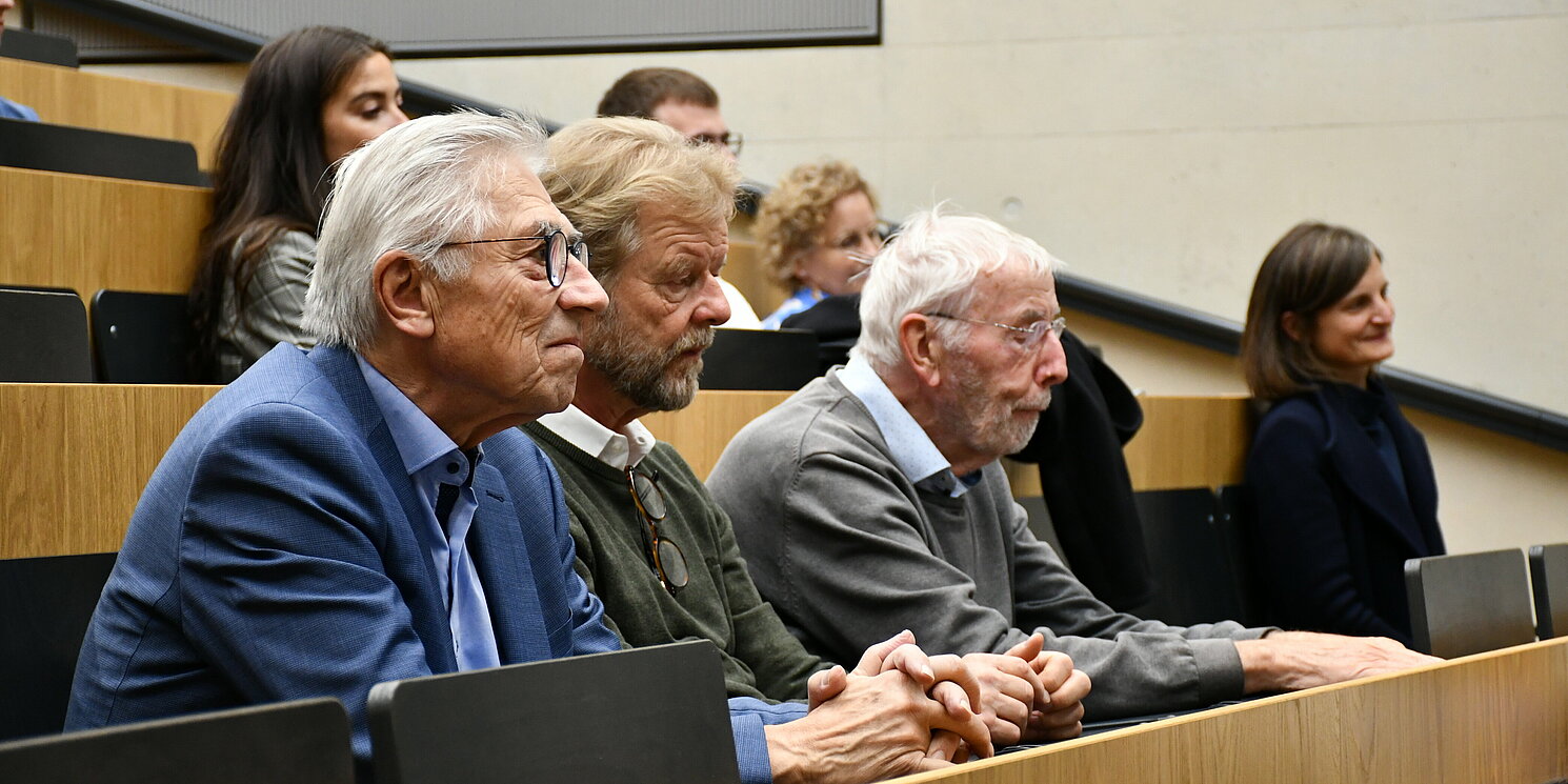 Personen sitzen in einem Hörsaal.